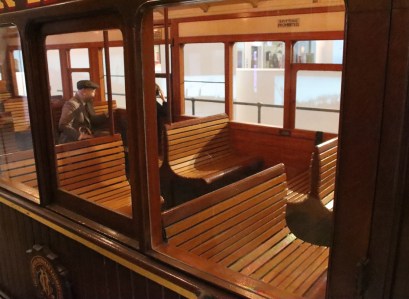 The curved seats made of wooden slats in 3rd Class